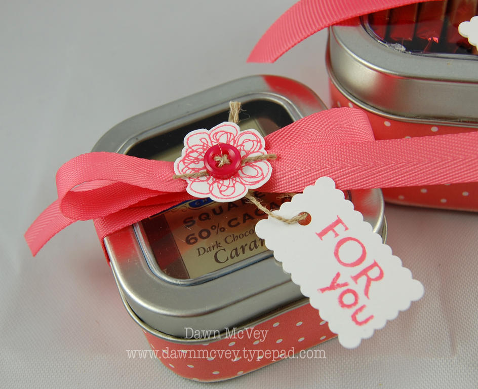 The 4oz. square clear top tin holds 4 Ghirardelli chocolate squares laying flat on their backs.