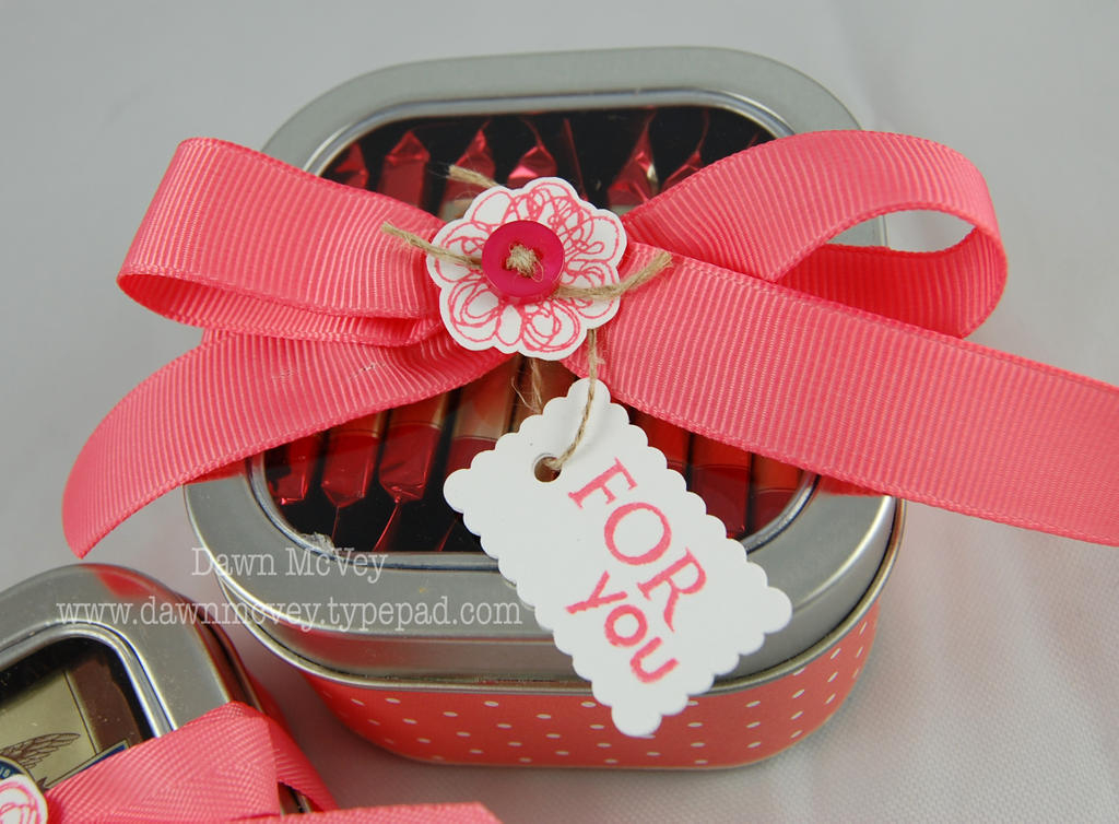 The 8oz square clear top tin holds 10 Ghirardelli chocolate squares comfortably, if you stand...