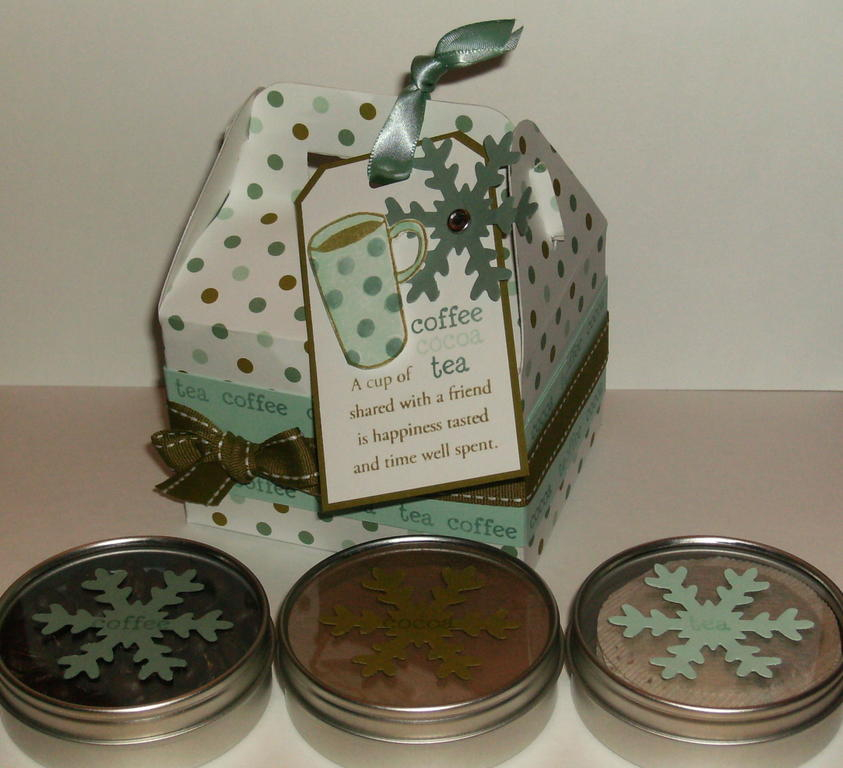 Small round clear top tins filled with coffee beans, cocoa powder, and round tea bags