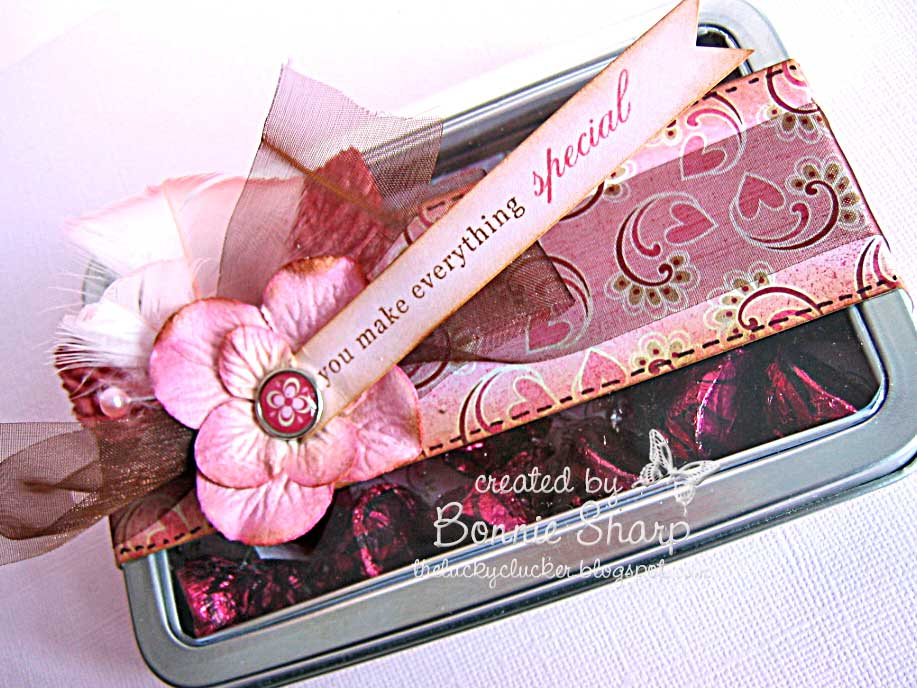 I decorated a tin with layered embellishments and added a small flagged sentiment combining the...