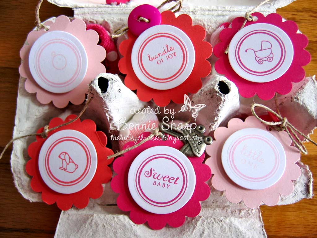These are baby socks tied with twine and with tags attached and nestled inside a half dozen egg...