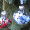 vintage buttons are used in a glass ornament ball and tied with satin ribbon for a hanger.