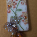 Wooden domino, sanded, then painted with acrylic paint, stamped and then sealed with 2 coats of ultrathick embossing powder. Punched hole with cropadile and added beads and ribbon.